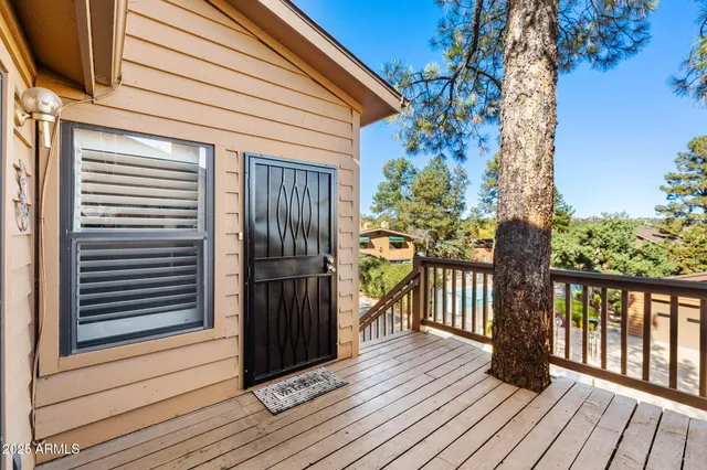 a view of a balcony with wooden floor and floor to ceiling window