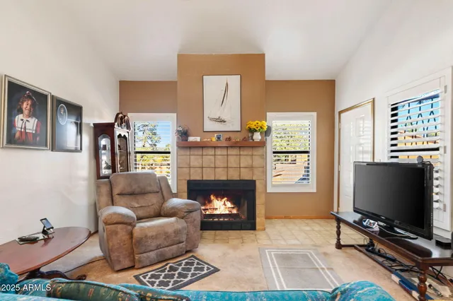 a living room with furniture a flat screen tv and a fireplace