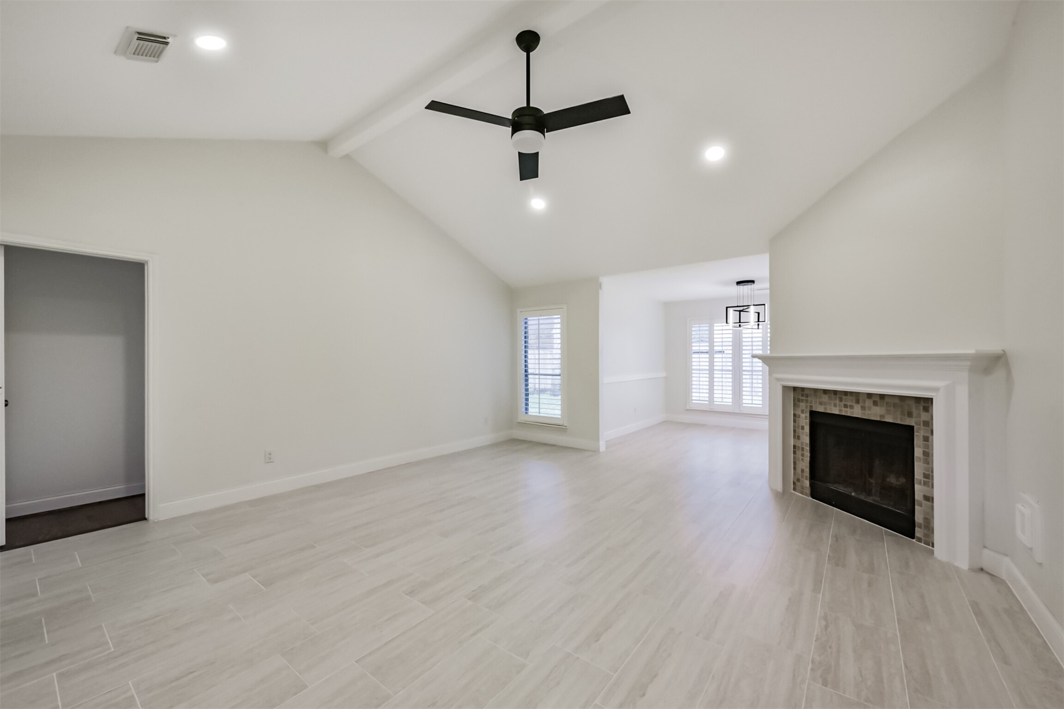9202 Bayou Bluff Drive Spring, TX 77379 - Photo 6 of 33 an empty room with windows a fireplace a sink and wooden floor