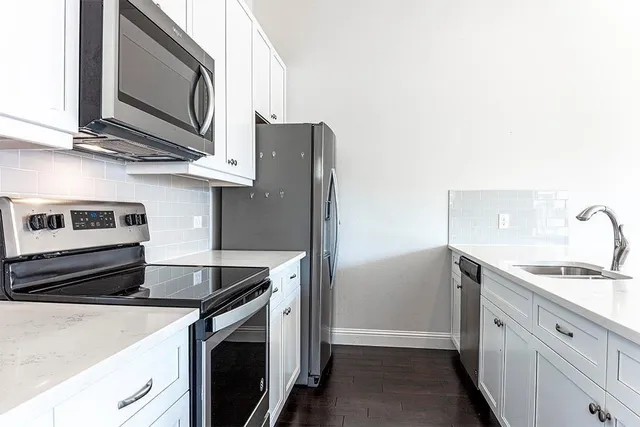 a kitchen with stainless steel appliances granite countertop a sink stove and microwave