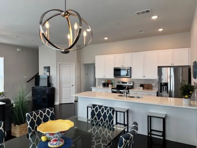 a kitchen with stainless steel appliances a dining table and chairs