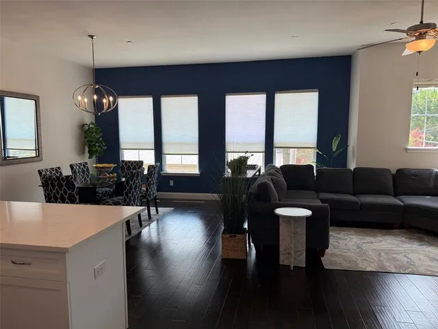 a living room with furniture wooden floor and a large window