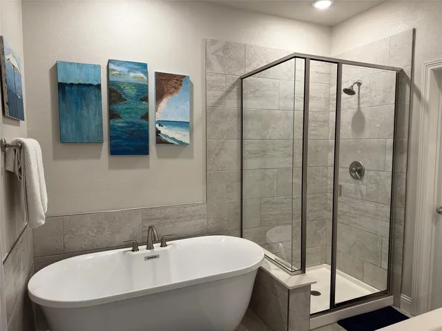 a bathroom with a white bath tub and a shower