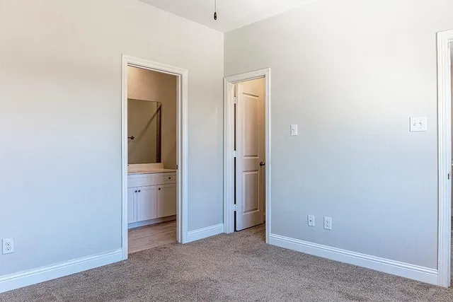 an empty room with closet and a bathroom