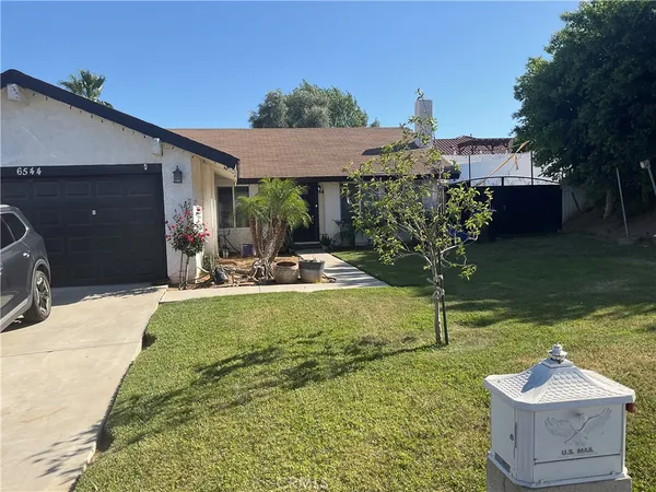 a view of a house with backyard and sitting area