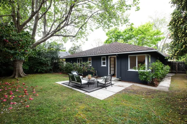 a view of a house with backyard sitting area and garden