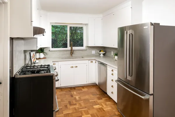 a kitchen with stainless steel appliances granite countertop a refrigerator and a sink