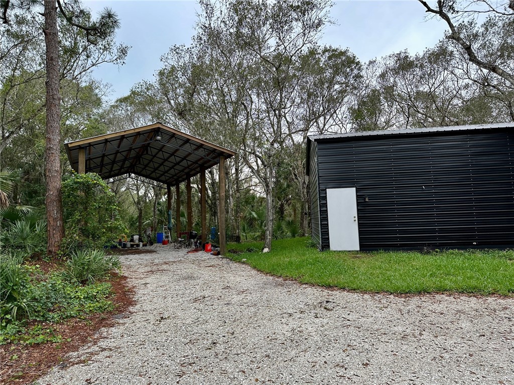 2465 Johnston Road Fort Pierce, FL 34951 - Photo 3 of 17 a side view of a house with backyard and trees