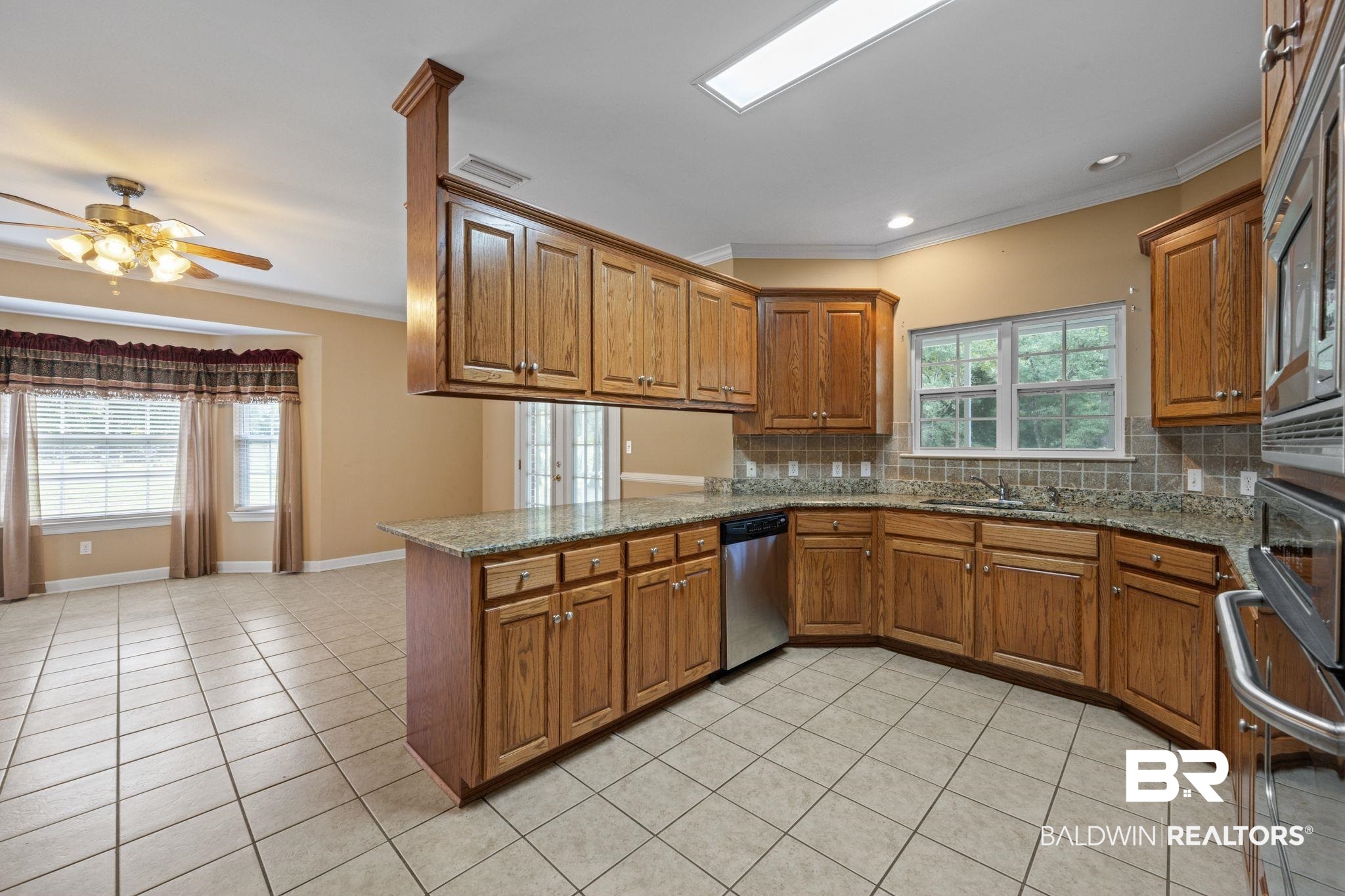 5618 Leytham Road Theodore, AL 36582 - Photo 18 of 60 Kitchen featuring decorative backsplash, stainless steel appliances, light tile patterned floors, and kitchen peninsula