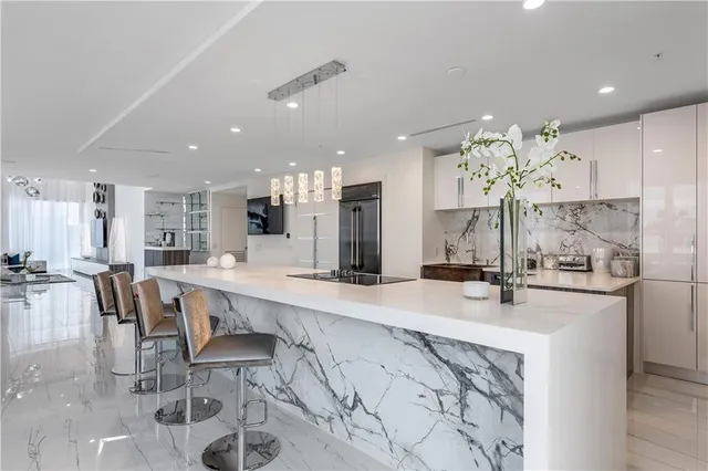 a cabinet with stainless steel appliances lots of different kinds of food