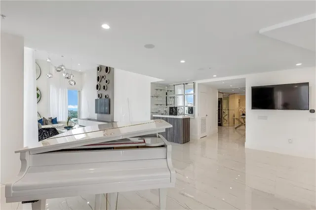 a large white kitchen with a large window and stainless steel appliances