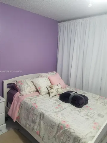 a bedroom with a bed and a curtain