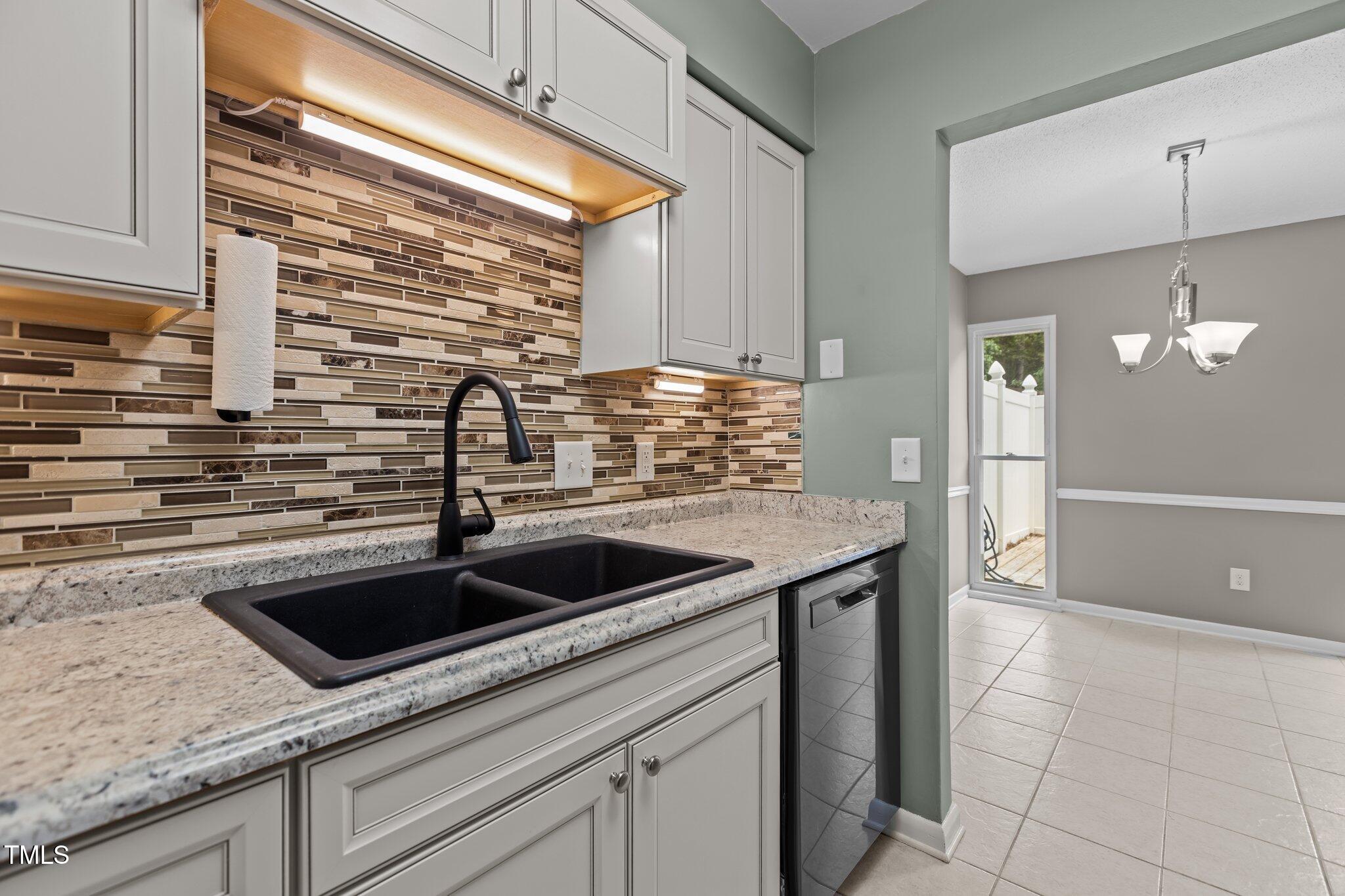 7159 Sandy Creek Drive Raleigh, NC 27615 - Photo 15 of 58 With tile backsplash, updated cabinets and faucet and stone sink.