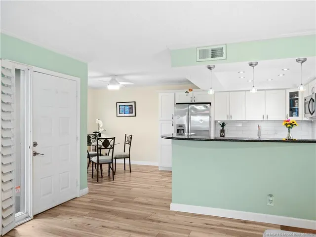 an entryway with wooden floor and cabinets