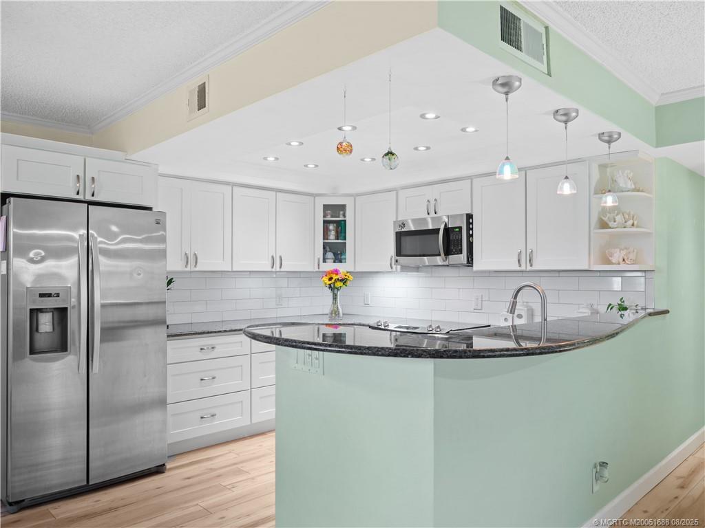 950 South Kanner Highway, Unit 101 Stuart, FL 34994 - Photo 14 of 32 a kitchen with stainless steel appliances granite countertop a sink a refrigerator and a granite counter tops