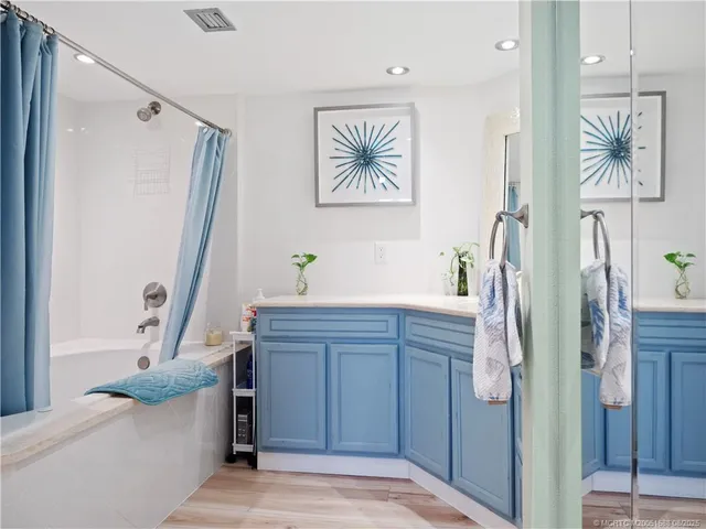 a bathroom with a tub sink and mirror