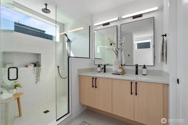a bathroom with a double vanity sink mirror and shower