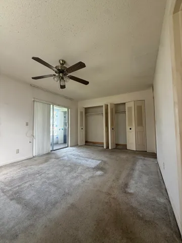 a view of a livingroom with a ceiling fan and window