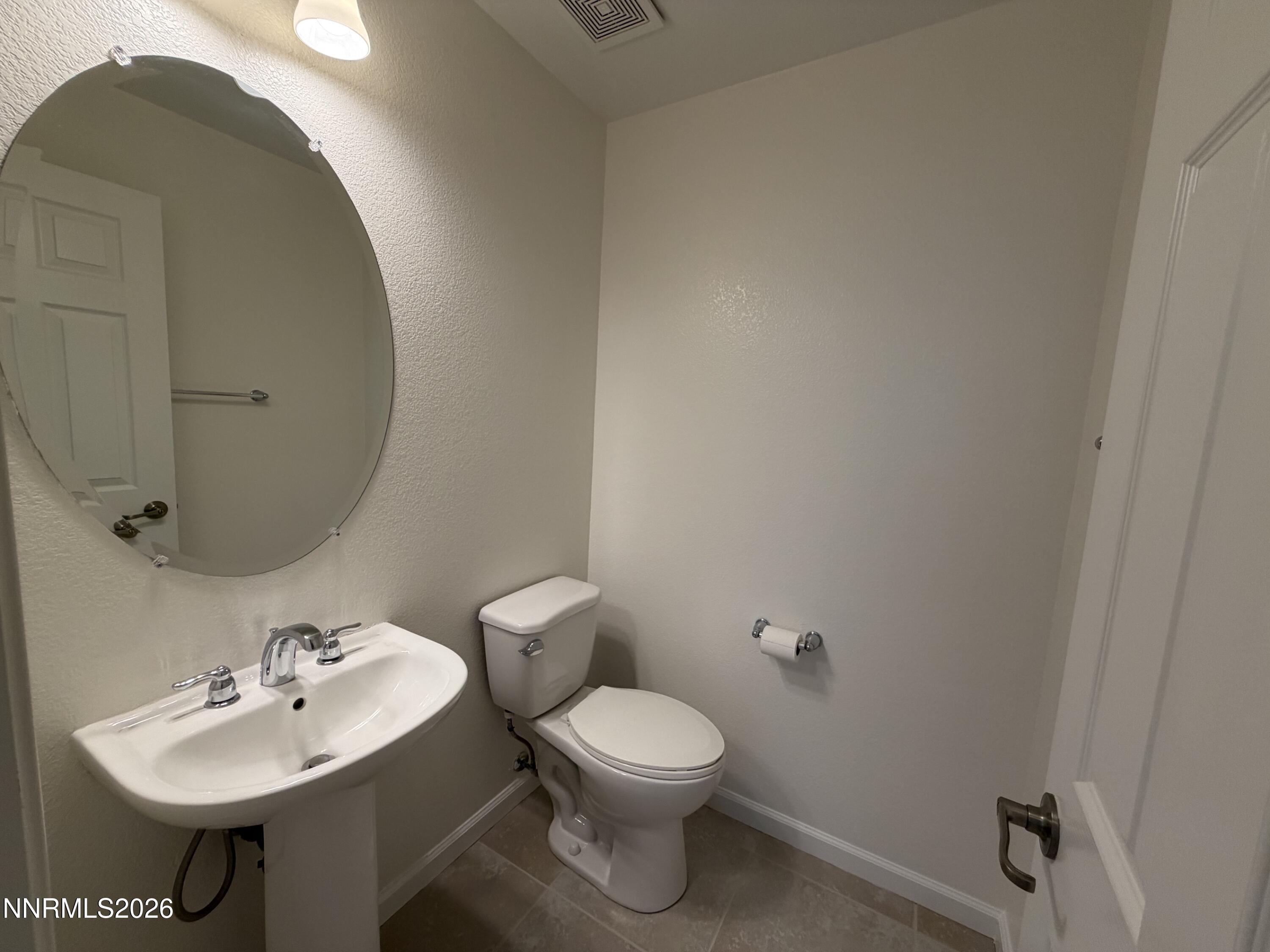 10890 Oakhaven Drive Reno, NV 89521 - Photo 18 of 28 a bathroom with a toilet a sink and mirror