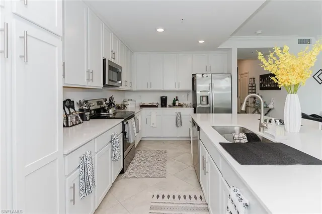 a kitchen with stainless steel appliances kitchen island granite countertop a sink a stove and cabinets