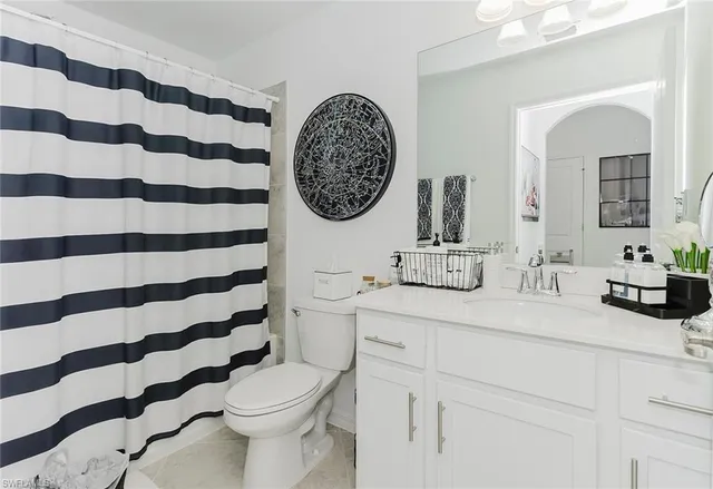 a bathroom with a sink and mirror with bathtub