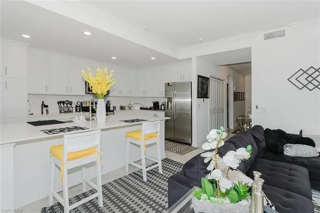 a kitchen with stainless steel appliances kitchen island granite countertop a table chairs in it and a wooden floor