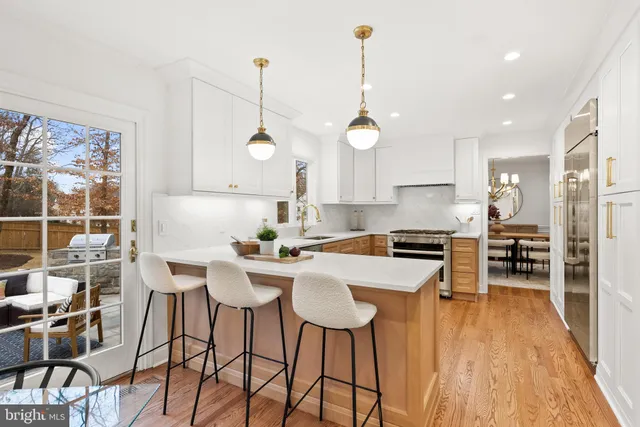 a kitchen with a table chairs stove and wooden floor