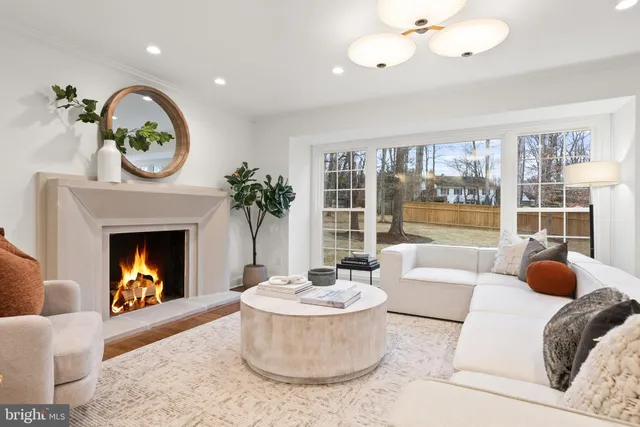 a living room with furniture a large window and wooden floor