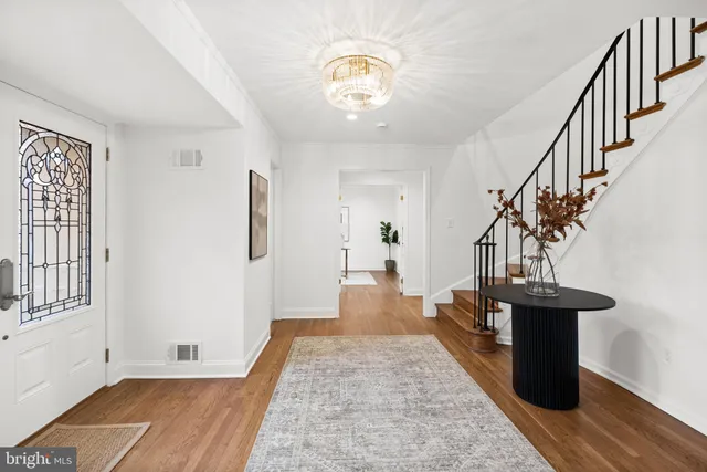a view of a hallway with wooden floor and staircase