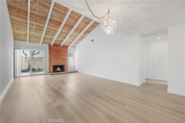 an empty room with wooden floor and window