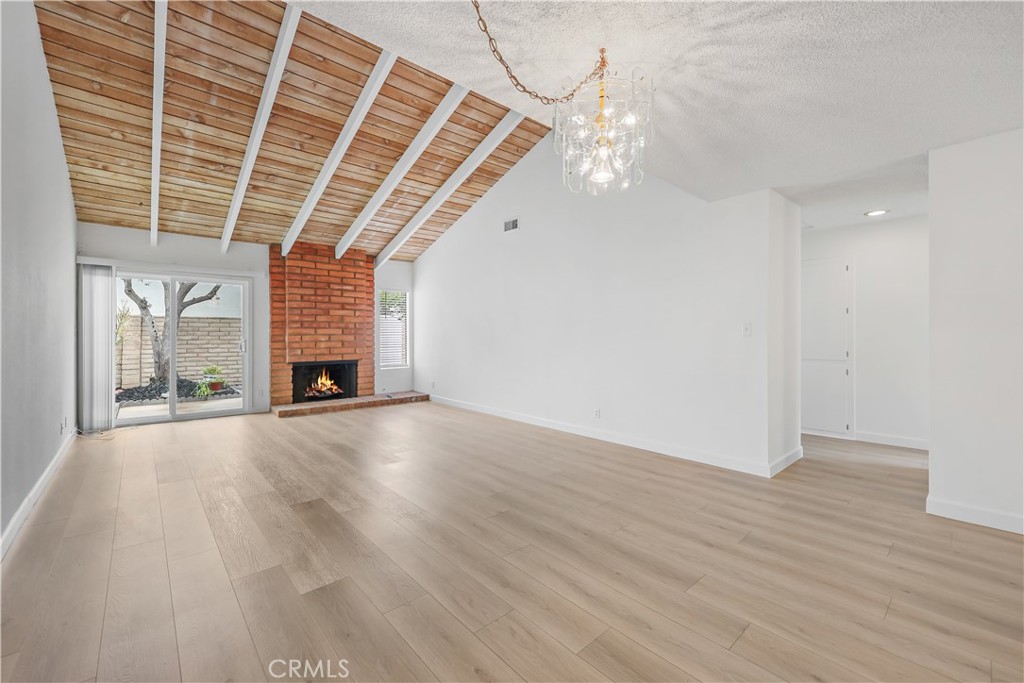 an empty room with wooden floor and window