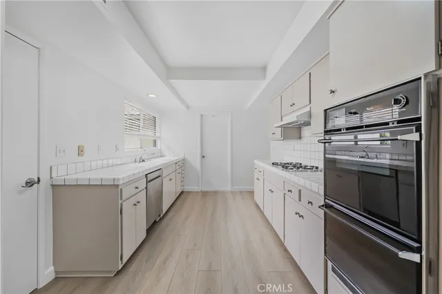 a kitchen with white cabinets and white appliances