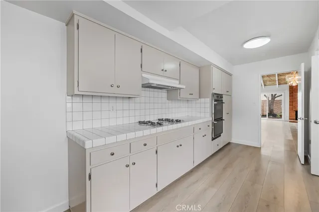 a large white kitchen with cabinets