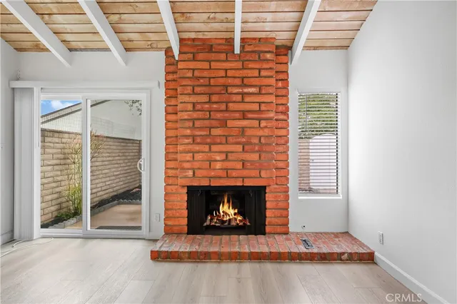 a living room with fireplace and a wooden floor