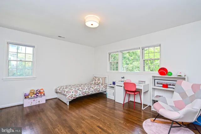 a bedroom with furniture and a wooden floor