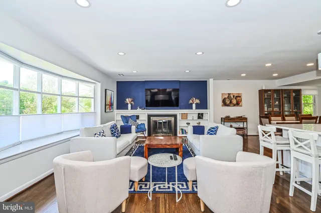a living room with fireplace furniture and a large window