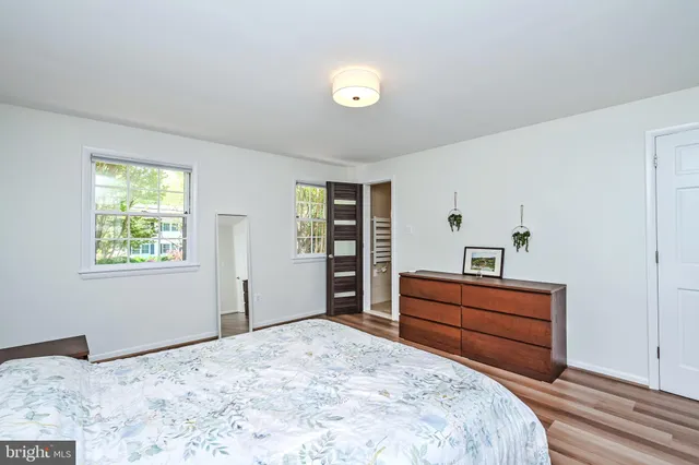 a bedroom with a bed and a dresser next to a window