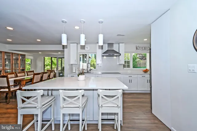 a kitchen with a table chairs and white cabinets