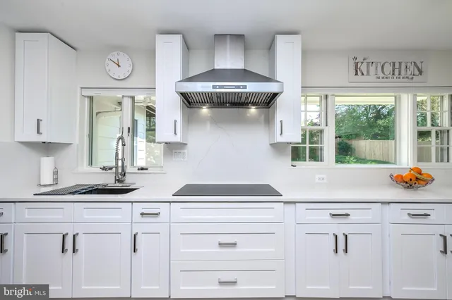 a kitchen with white cabinets and a sink