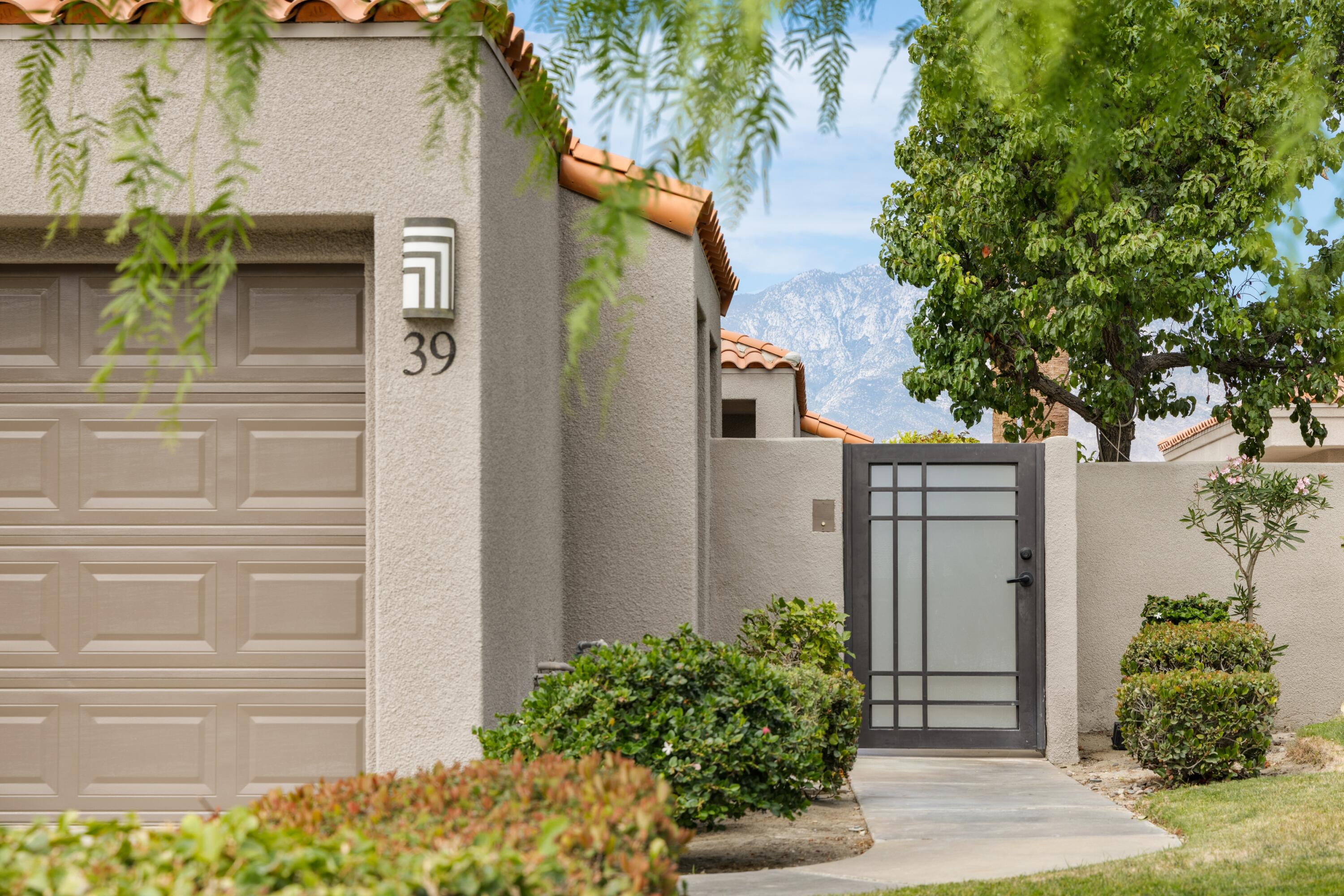 39 Augusta Drive Rancho Mirage, CA 92270 - Photo 4 of 53 a front view of a house with a garden