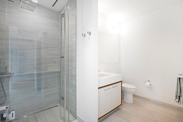 a bathroom with a granite countertop toilet and a shower