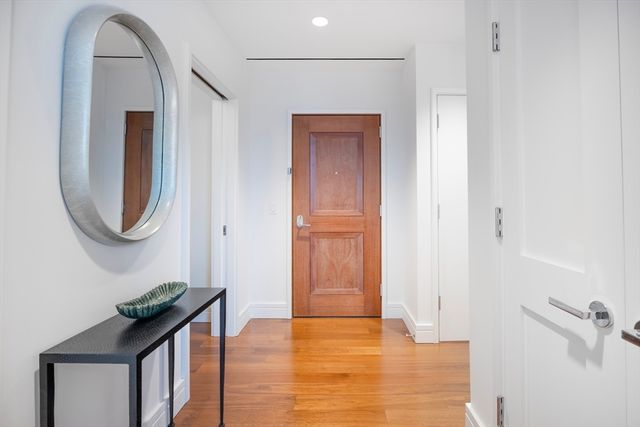 a hallway with a large mirror and a wooden door