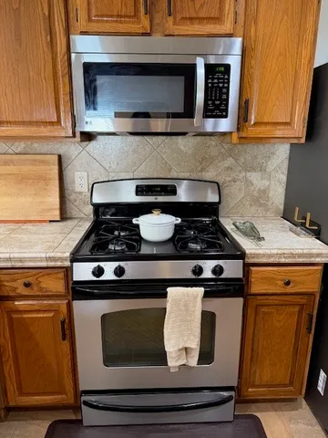 a stove top oven sitting inside of a kitchen