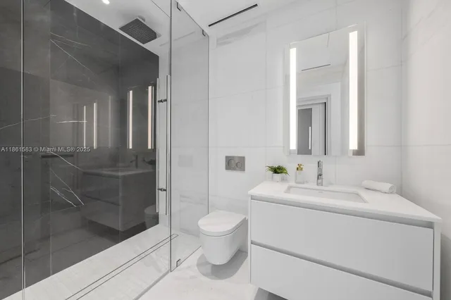 a bathroom with a sink a toilet and shower