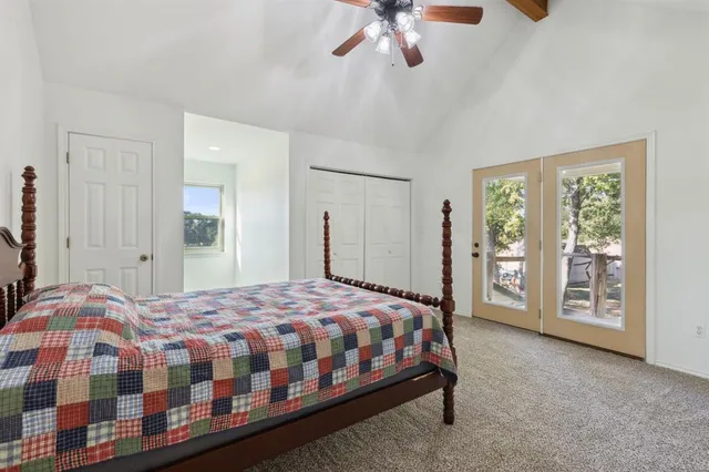 a bedroom with a bed a chandelier and balcony