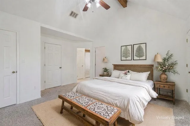 a spacious bedroom with a bed and a chandelier