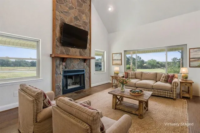 a living room with furniture a fireplace and a flat screen tv