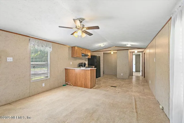 a view of a livingroom with a ceiling fan and window