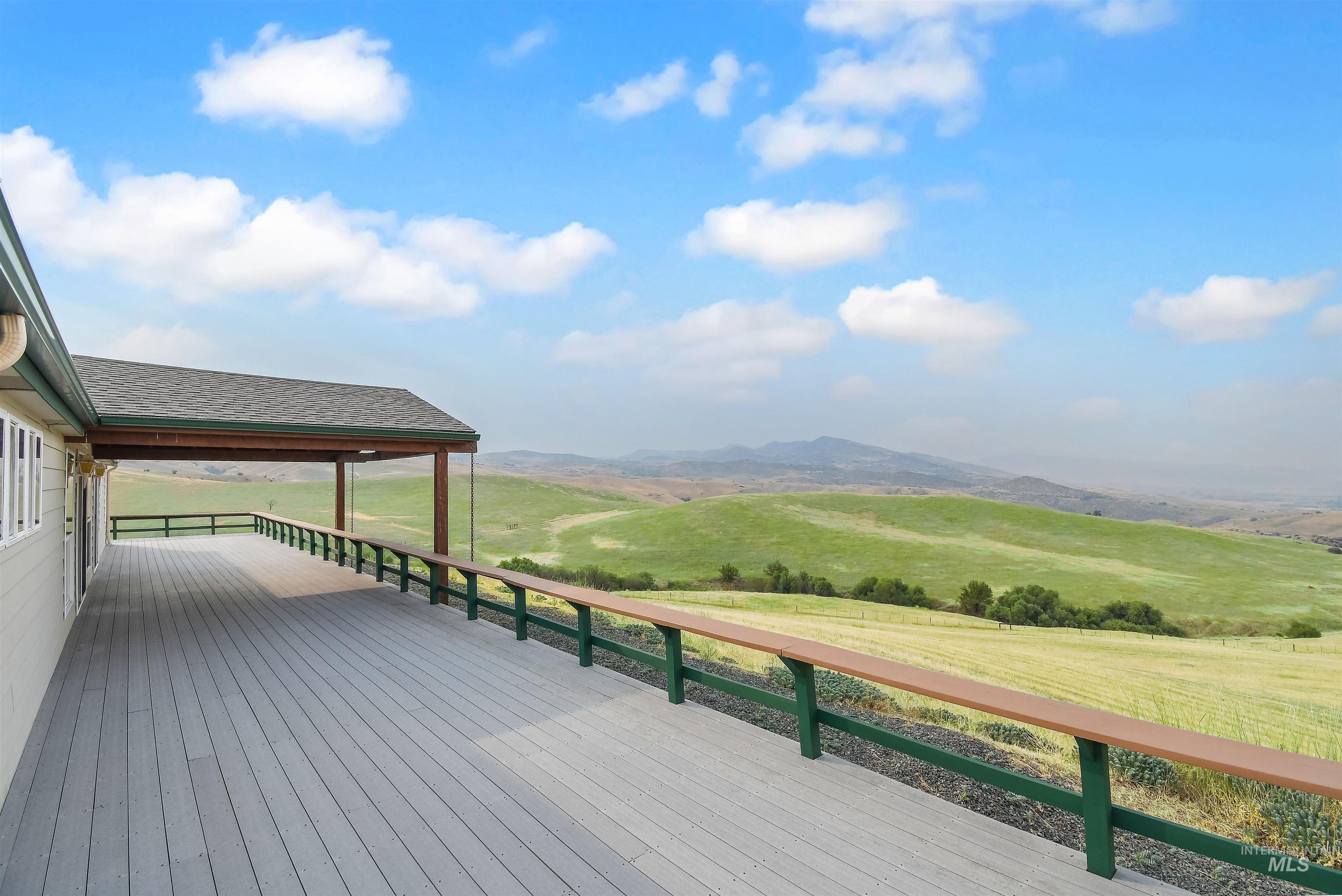 11375 Timber Butte Road Sweet, ID 83670 - Photo 35 of 49 Expansive deck featuring composite decking, a partial covered area, and a railing with a wood-finish top
