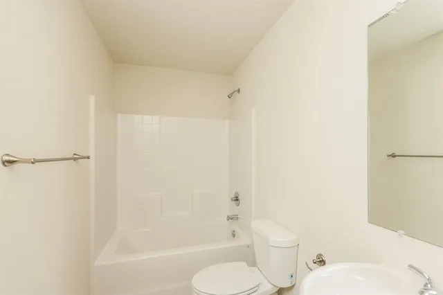 a white toilet sitting next to a bath tub